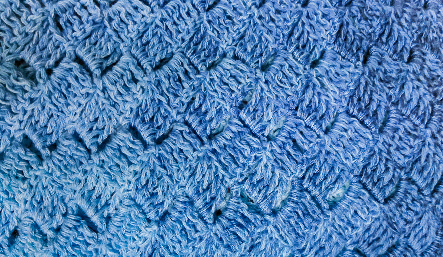 Close-up of crocheted shawl in a blue gradient ayrn